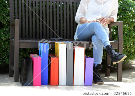 Woman relaxing on bench outside shopping center Woman relaxing on bench outside shopping center 32846655