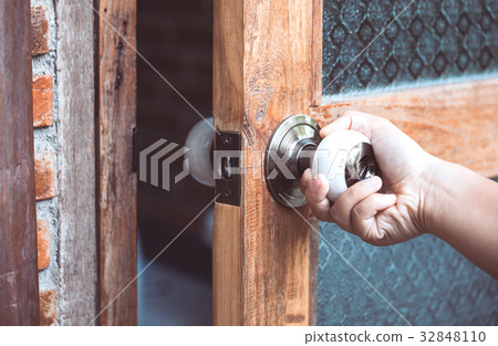 Woman hand opening/closing door knob Woman hand opening/closing door knob 32848110
