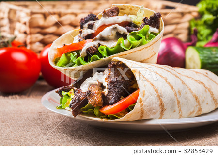 Tasty fresh wrap sandwich with beef and vegetables 32853429