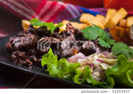 Kebab of beef with french fries and salad 32853437