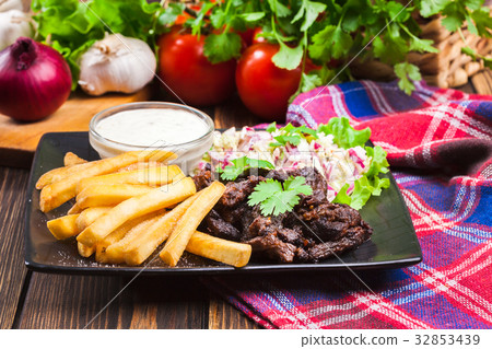Kebab of beef with french fries and salad 32853439
