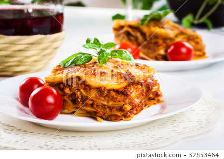 Piece of tasty hot lasagna with red wine.. 32853464