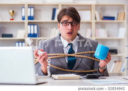 Businessman tied up with rope in office Businessman tied up with rope in office 32854942