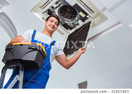Worker repairing ceiling air conditioning unit Worker repairing ceiling air conditioning unit 32855463