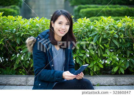 Woman use of mobile phone at outdoor park 32860847