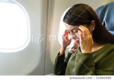 Woman in plane suffer from airsick with stress headache 32860886