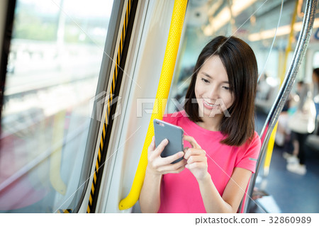 Woman use of cellphone inside train compartment 32860989