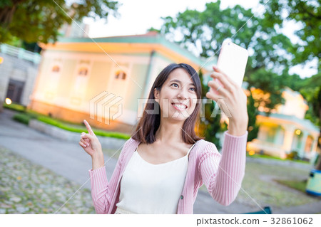 Woman taking selfie by mobile phone in Taipa of Macau city 32861062