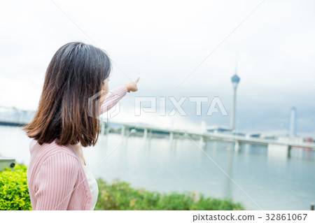 Woman travel in Macao city and finger pointing to the tower Woman travel in Macao city and finger pointing to the tower 32861067