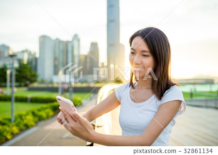 Asian woman use of cellphone in sunset 32861134