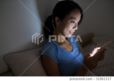 Woman using cellphone at night 32861317