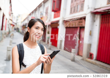 Woman searching something on mobile phone in Rua da felicidade 32861319