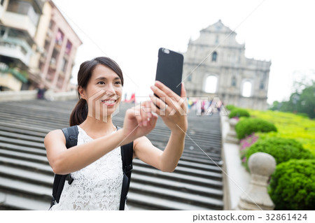 Woman taking selfie by mobile phone in Macao 32861424