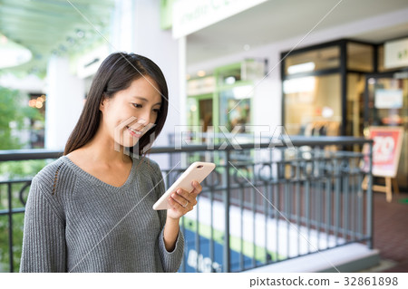 Woman using cellphone in shopping mall Woman using cellphone in shopping mall 32861898