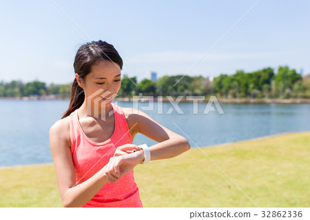 Woman using smart watch at outdoor park 32862336