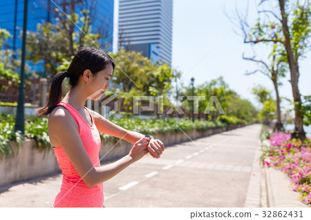 Sport Woman running with smart watch in park 32862431