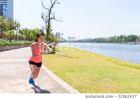 Sport woman running in the park and using smart watch 32862437