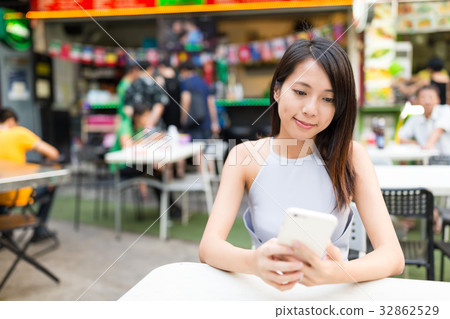 Woman using mobile phone at outdoor market 32862529