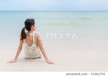 Woman sitting on the sand beach Woman sitting on the sand beach 32862702