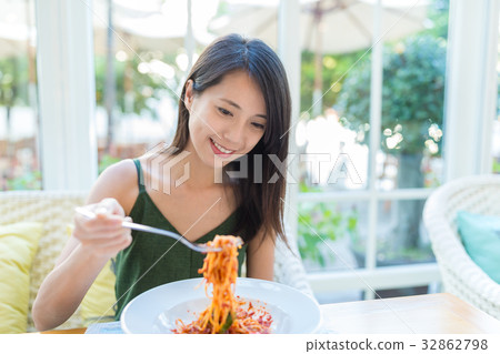 Woman enjoy her spaghetti in restaurant Woman enjoy her spaghetti in restaurant 32862798