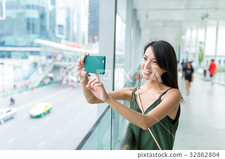 Woman taking photo with cellphone in Bangkok city Woman taking photo with cellphone in Bangkok city 32862804