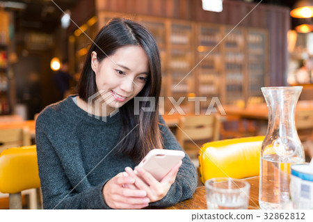 Woman use of mobile phone in restaurant 32862812