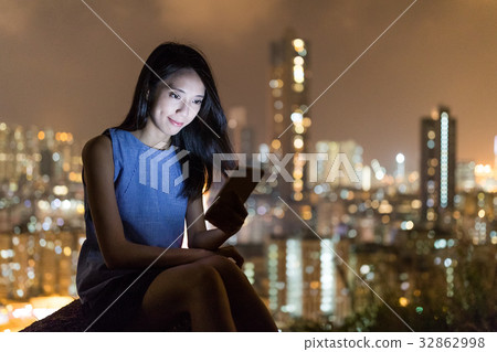 Woman use of mobile phone with the background of city Woman use of mobile phone with the background of city 32862998