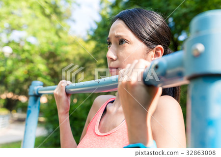 Sport Woman doing Pull up at green park Sport Woman doing Pull up at green park 32863008