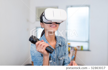 Woman play game with virtual reality device and joystick Woman play game with virtual reality device and joystick 32863017