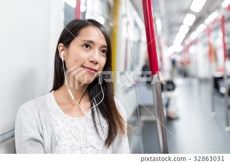 Woman listen to music on cellphone on train 32863031