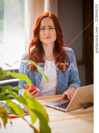 Freelancer woman at working place with sad face. Freelancer woman at working place with sad face. 32864829