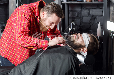 Barber making beard haircut using shaver 32865764