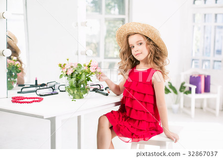 A little girl with cosmetics. She is in mother's A little girl with cosmetics. She is in mother's 32867037
