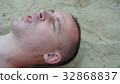 a young man lies on the sand on the beach 32868837
