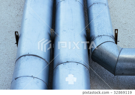 The pipes on the exterior wall of a building 32869119