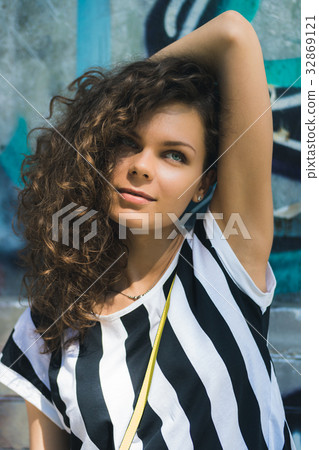 Woman with curly hair in a striped T-shirt Woman with curly hair in a striped T-shirt 32869121