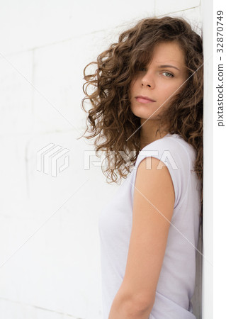 Young attractive woman with curly brown hair Young attractive woman with curly brown hair 32870749