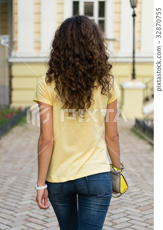 Attractive slim young woman with curly brown hair Attractive slim young woman with curly brown hair 32870755