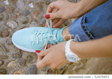 Women's hands with a red manicure knotted laces 32870953