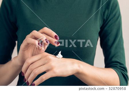 Woman in a green T-shirt and a maroon manicure 32870958
