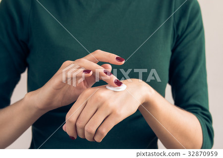 Woman in a green T-shirt and a maroon manicure Woman in a green T-shirt and a maroon manicure 32870959