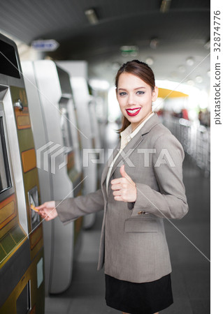 Business women using card at automatic machine. Business women using card at automatic machine. 32874776