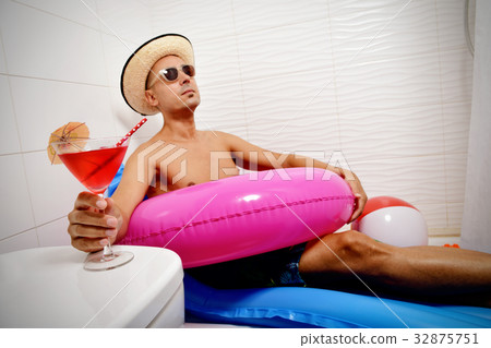 man with a swim ring relaxing in the bathroom man with a swim ring relaxing in the bathroom 32875751