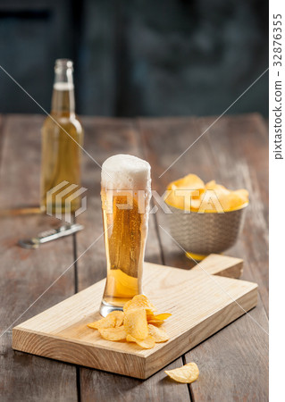 Beer glass and potato chips, pistachios isolated Beer glass and potato chips, pistachios isolated 32876355