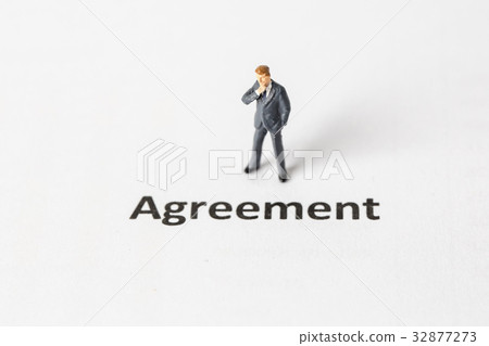 Miniature model of businessman standing agreement. Miniature model of businessman standing agreement. 32877273