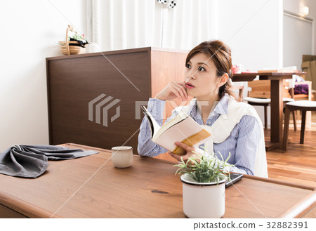 A lady who reads in the living room 32882391