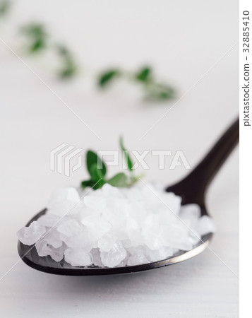 coarse sea salt in black spoon with thyme 32885410