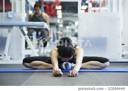 A woman is stretching at a sport club 32886444