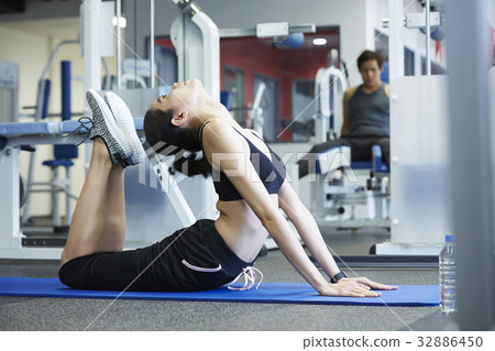 A girl is doing yoga exercise at a room 32886450