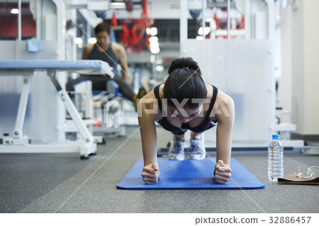 A young woman is practising hardly at a fitness room A young woman is practising hardly at a fitness room 32886457